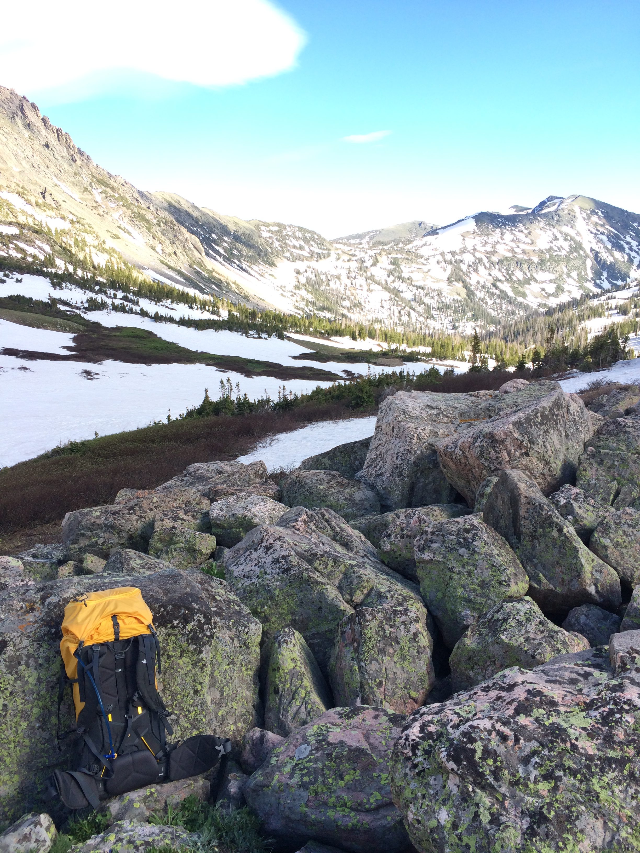 Backpack resting against rocks during break from hiking. 